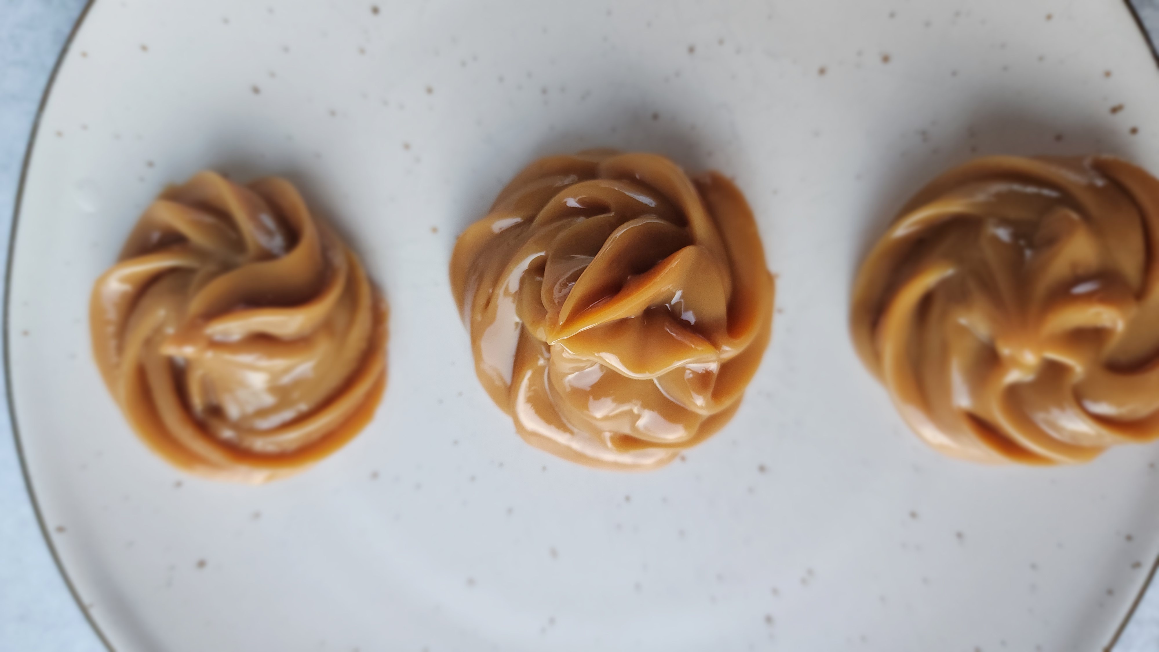 plate of piped dulce de leche dollops on a plate for Instant Pot Dulce de Leche