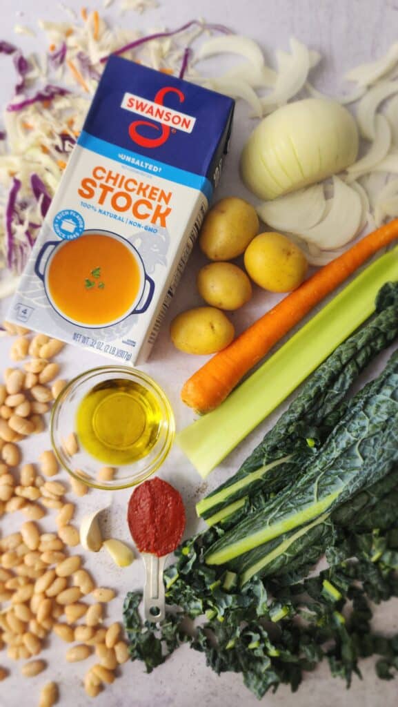 ingredients for easy ribollita soup: chicken stock, white beans, olive oil, carrots, onion, celery, kale, cabbage, tomato paste, potatoes