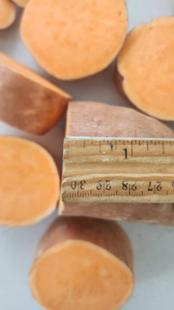 sweet potatoes being cut into 1-inch discs for melting sweet potatoes