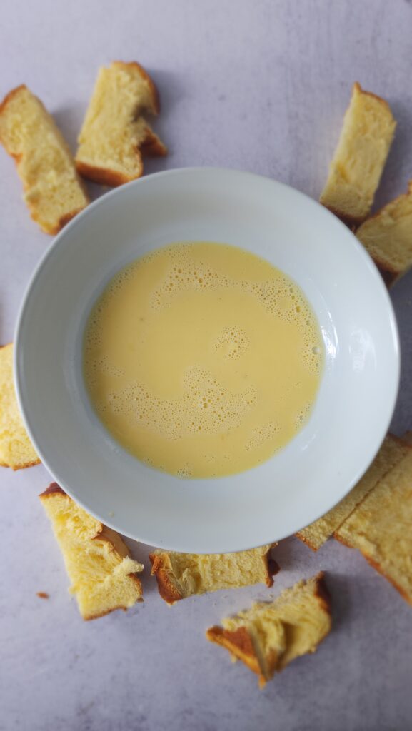 Beaten egg in a bowl ready to have the Brioche bread dipped to make Air Fryer French Toast Sticks