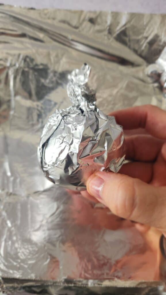 aluminum foil packet with a beet to roast wrapped
