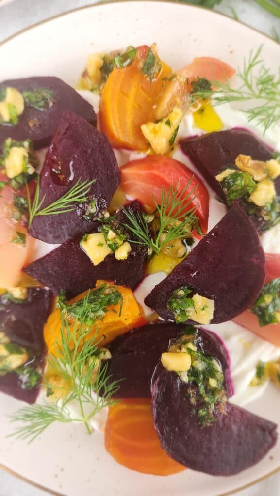 plate of roasted beets over labneh with a drizzle of olive oil and walnut gremolata spooned on top