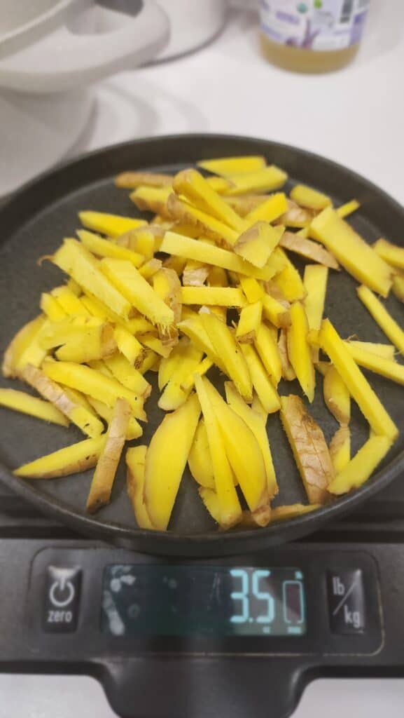cut up ginger to make ginger simple syrup for a Frozen Pomegranate Mocktails