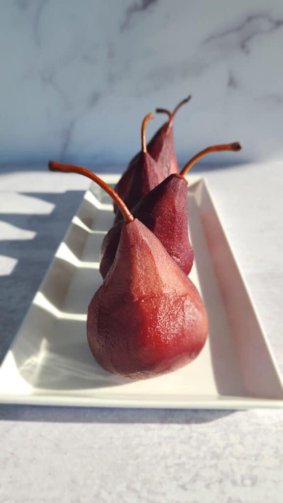 Red Wine Poached Pears on a serving platter in the light