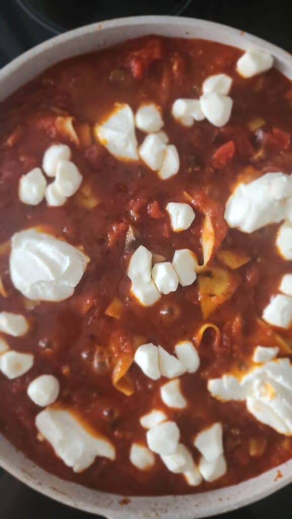 mozzarella being added to the skillet lasagna