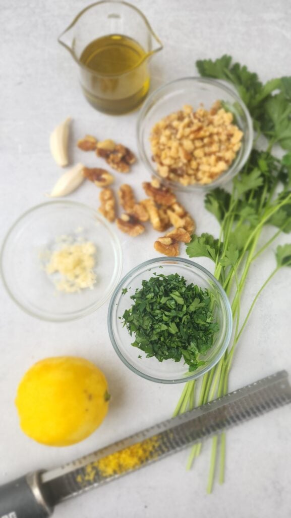 ingredients for walnut gremolata: parsley, garlic, walnuts, lemon zest, olive oil