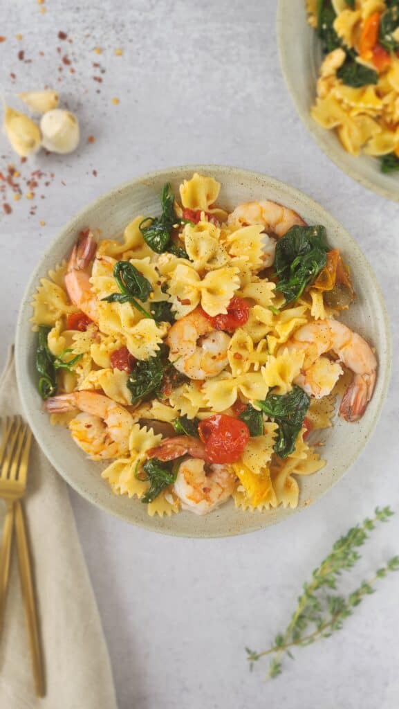 final plated dish of baked feta pasta with spinach and sauteed shrimp