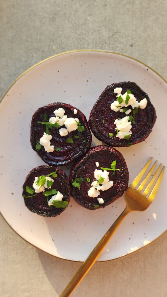 melting beets on a plate sprinkled with chopped parsley and crumbled goat cheese