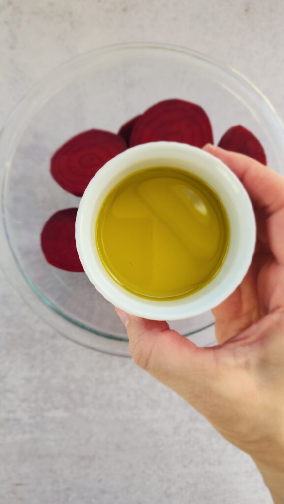 adding olive oil to the 1-inch beet discs for melting beets