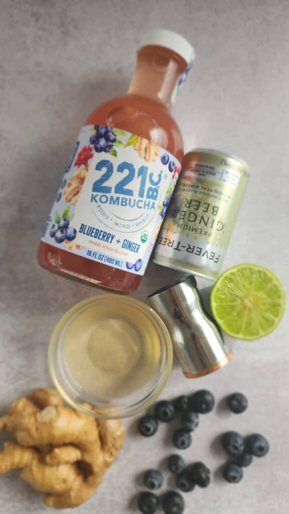 ingredients for a blueberry ginger mocktail: ginger simple syrup, lime juice, ginger beer, blueberry kombucha