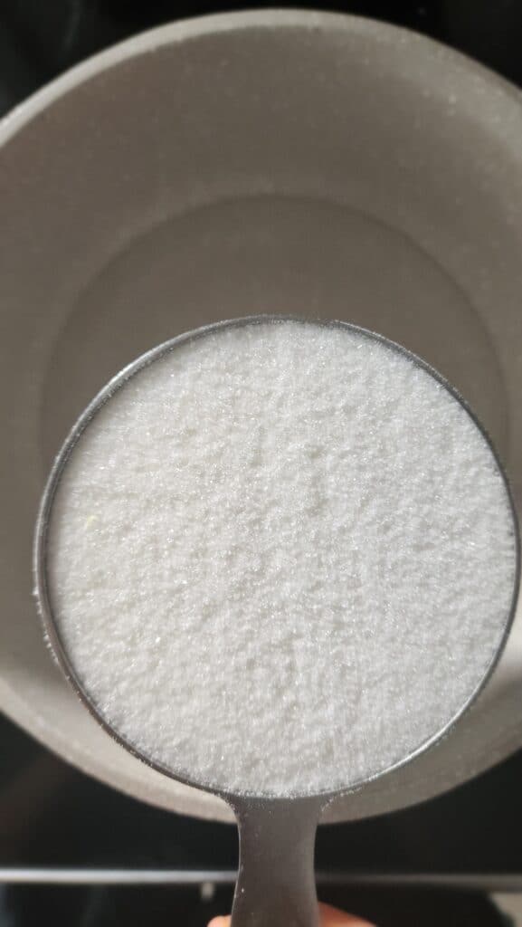 sugar being added to the water for ginger simple syrup