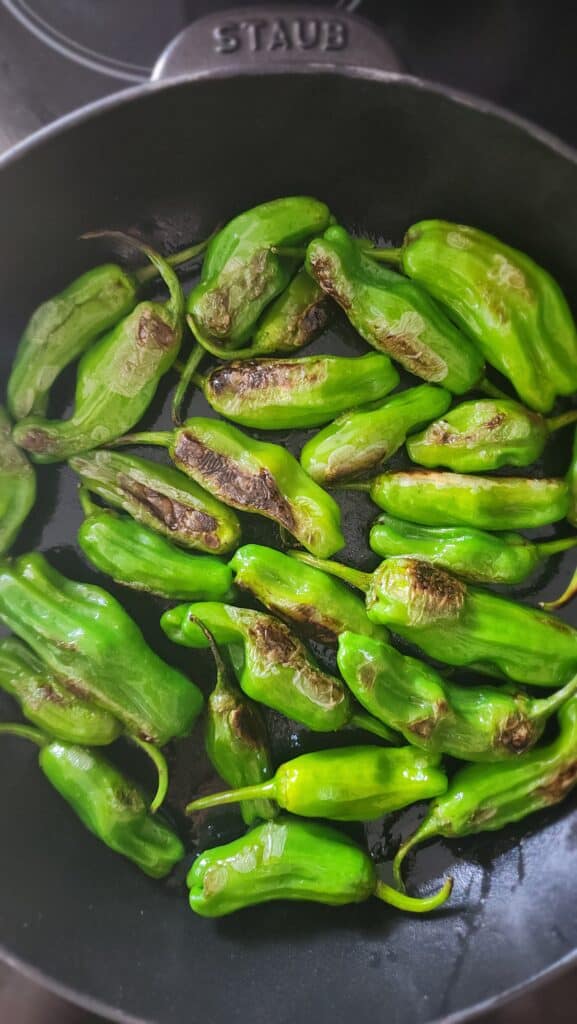 post-char on the shishito peppers in a cast-iron skillet