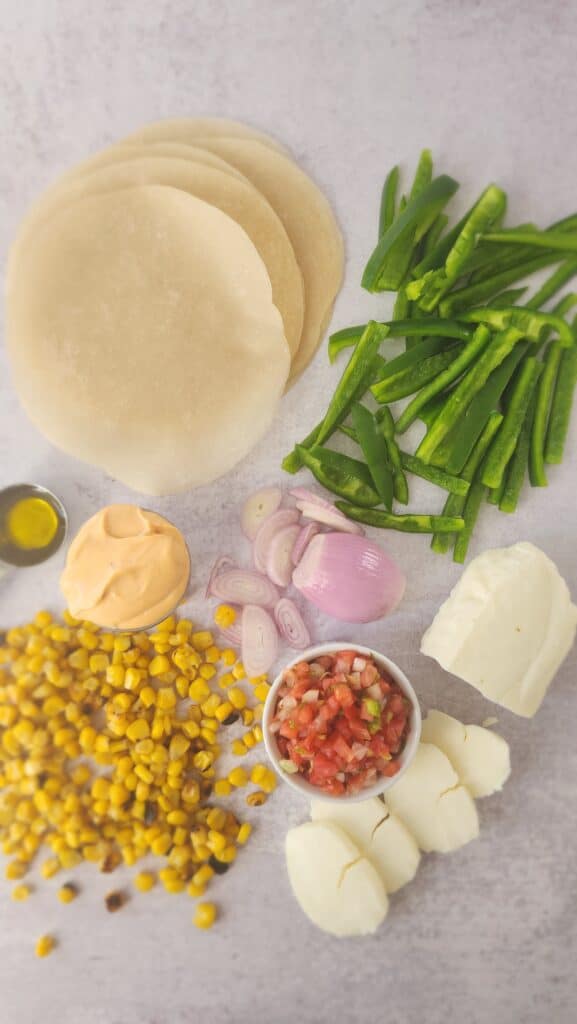 ingredients to make halloumi tacos: halloumi, shallot, green pepper, charred corn, pico de gallo, olive oil, chipotle mayonnaise