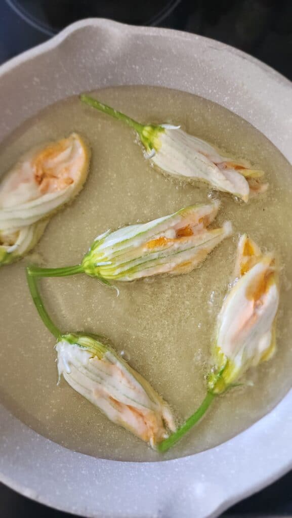 stuffed squash blossoms being fried