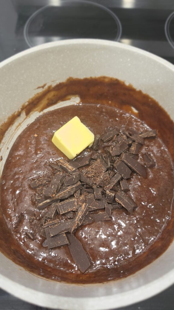 adding in the butter for hot fudge sauce