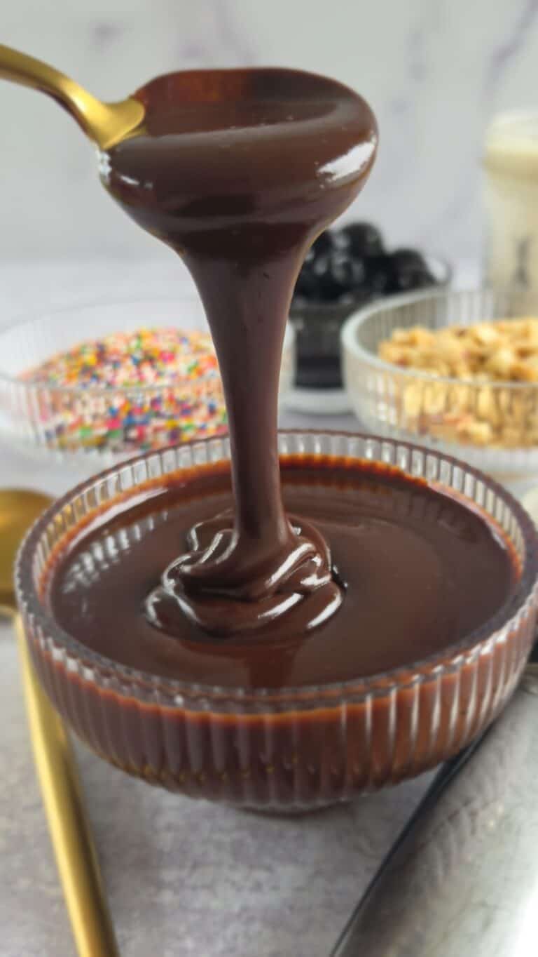 spoon drizzling hot fudge sauce