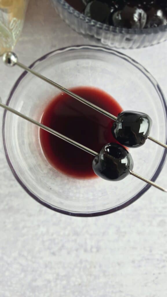 top shot of the garnish for a cherry bomb mule (two cherries on a skewer stick on top of the glass)
