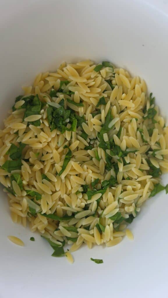cooked orzo with spinach wilted in