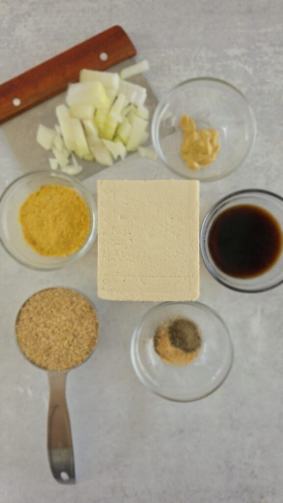 ingredients for glazed tofu loaf: extra-firm tofu, panko, cooked onion, nutritional yeast, garlic powder, black pepper, soy sauce