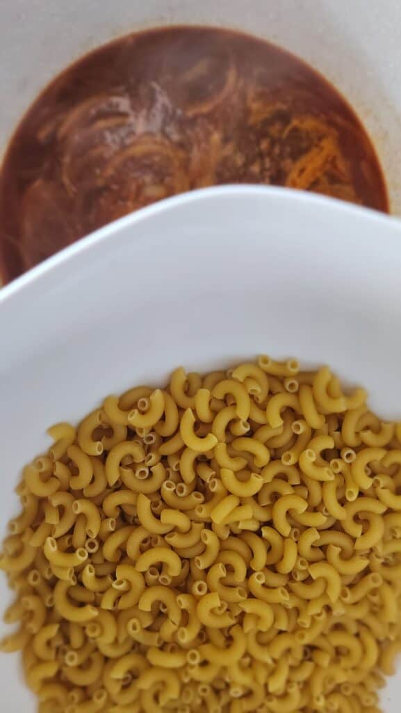 adding pasta to cook in the beef broth for homemade hamburger helper