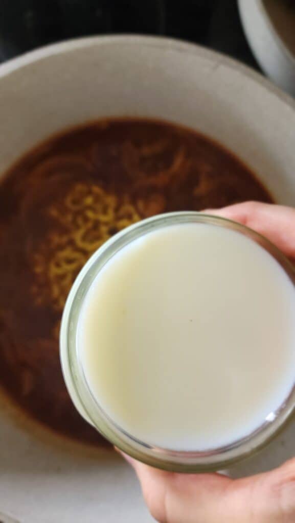 adding milk to the cooked ground beef
