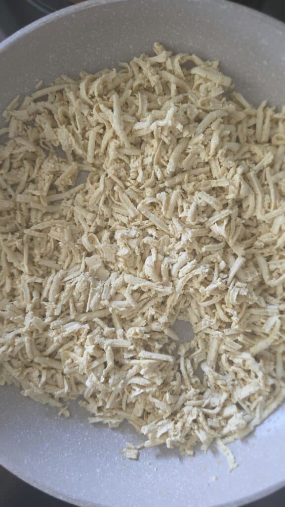 grated tofu in a sauté pan cooking for easy tofu lettuce wraps with mushrooms