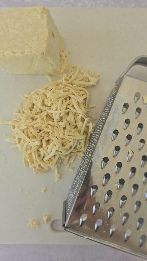 grated tofu on a box grater for easy tofu lettuce wraps with mushrooms