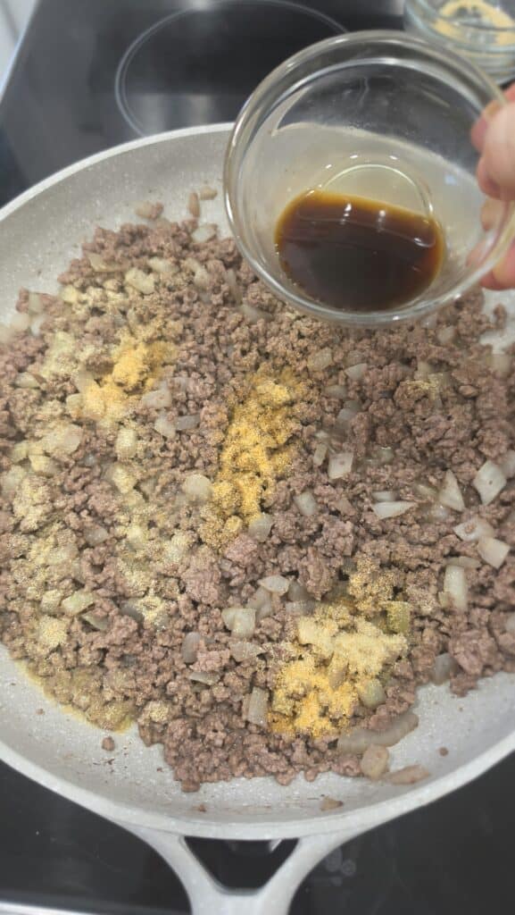 adding spices to the ground beef